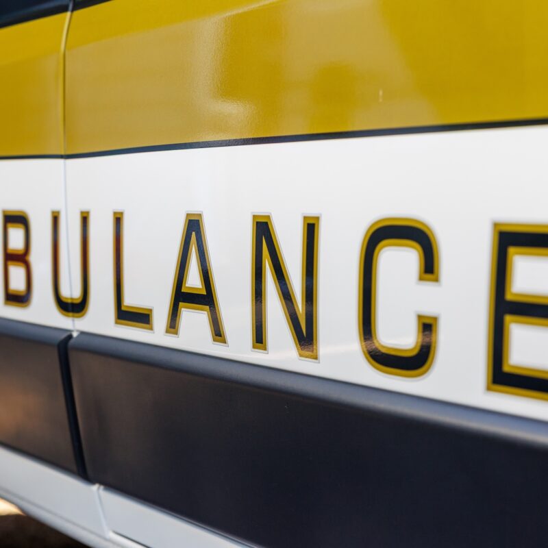 The side of an Oxford Health Systems ambulance, with the word 'Ambulance' on the side.