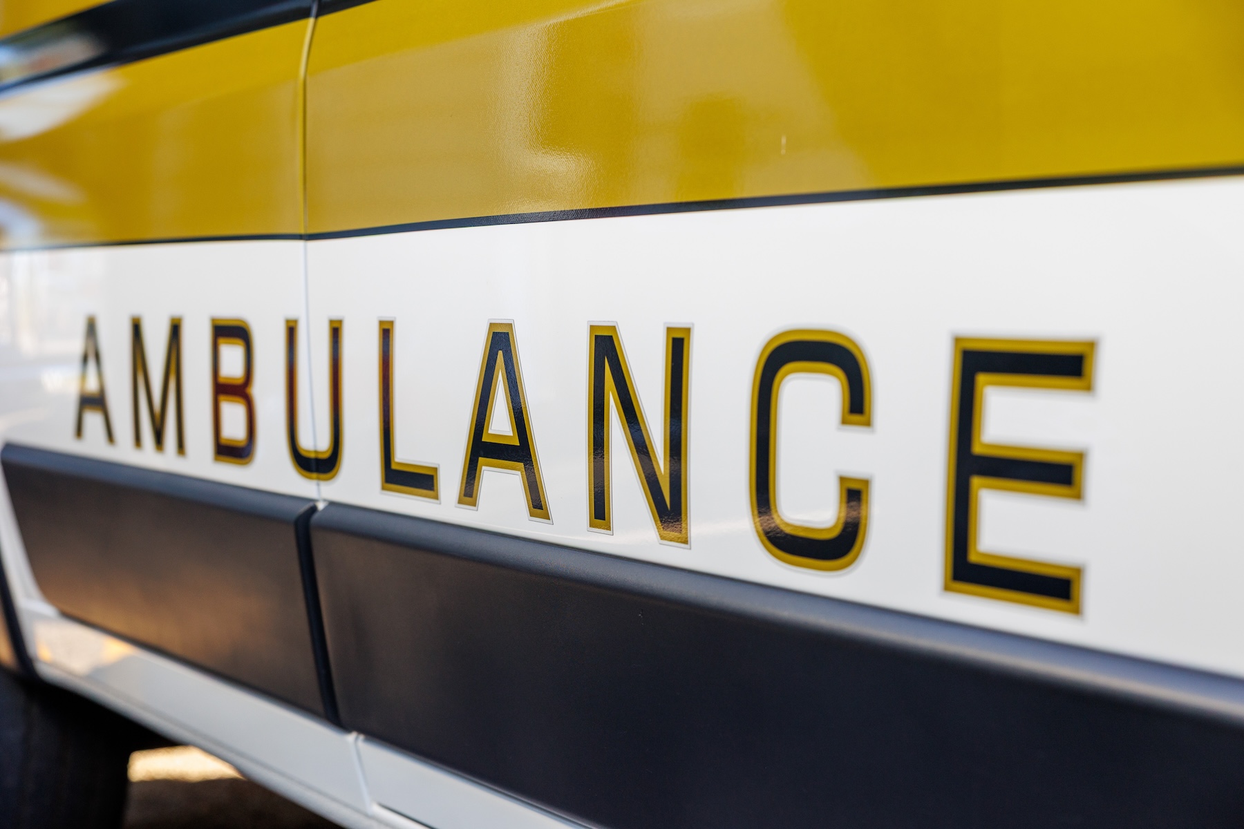 The side of an Oxford Health Systems ambulance, with the word 'Ambulance' on the side.